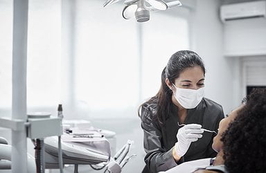 female-dentist-examining-patient